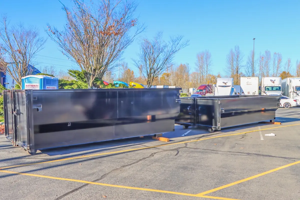 Professional dumpster rental service with roll-off container on residential driveway in Barnegat